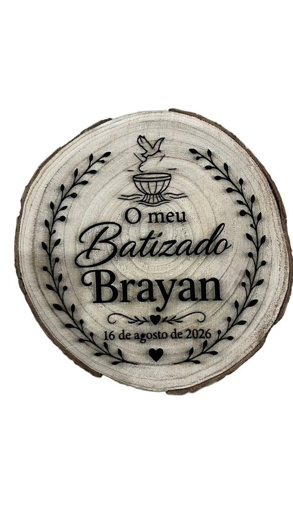 Rodela de madeira natural gravada a laser com texto 'O meu Batizado Brayan' e data, decorada com ramos e pombinha — vista frontal