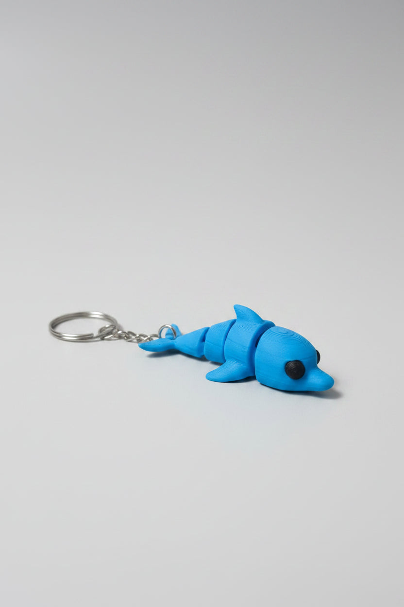 Porta-chaves golfinho articulado 3D azul com argola metálica, vista de cima
